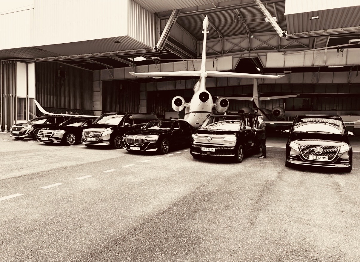 Flotte de véhicules Francelimo alignée devant un jet privé dans un hangar de l'aéroport du Bourget, chauffeur en tenue