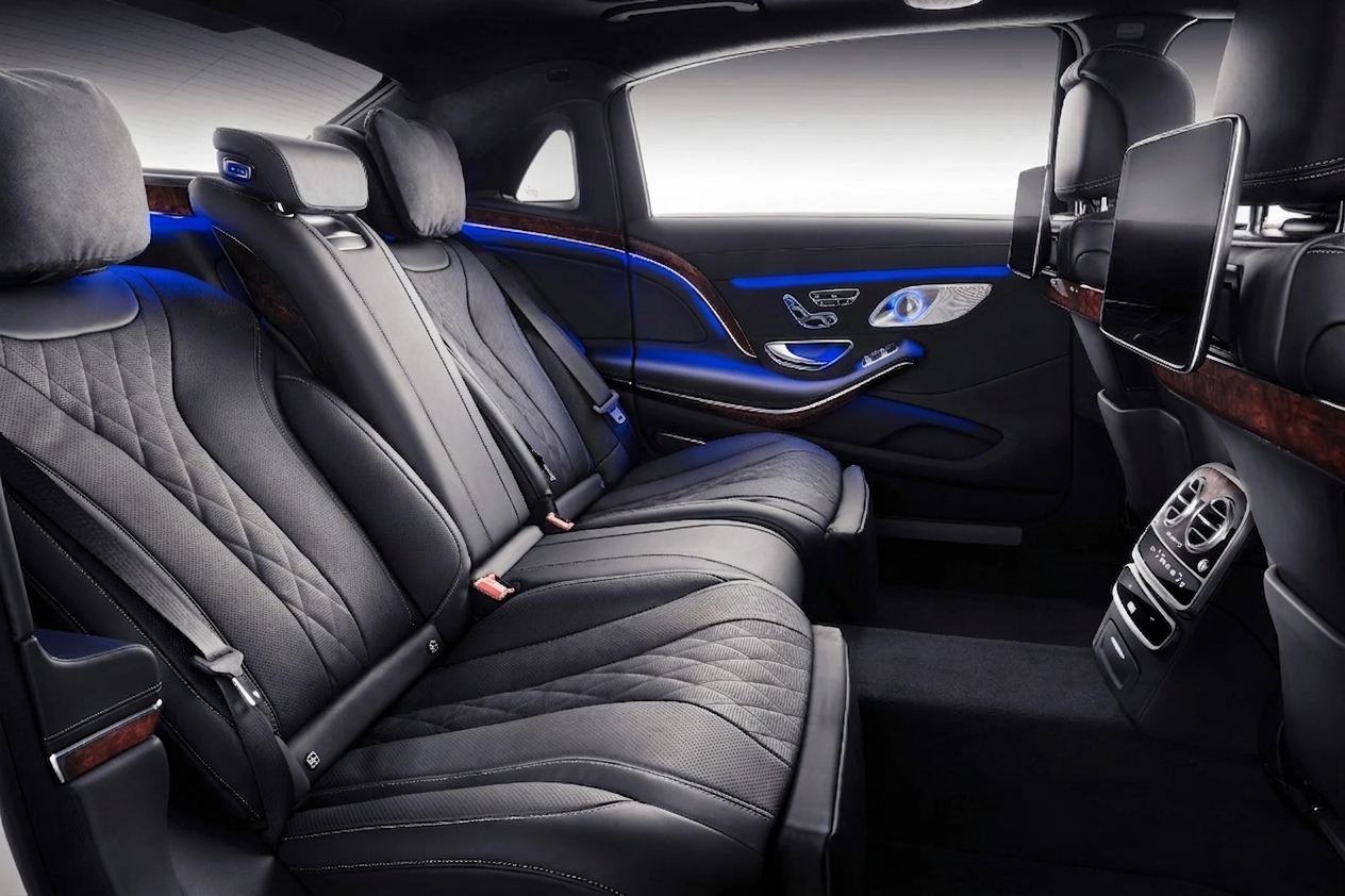 Habitacle arrière capitonné noir et bois précieux d'une Mercedes-Maybach Classe S, éclairage d'ambiance