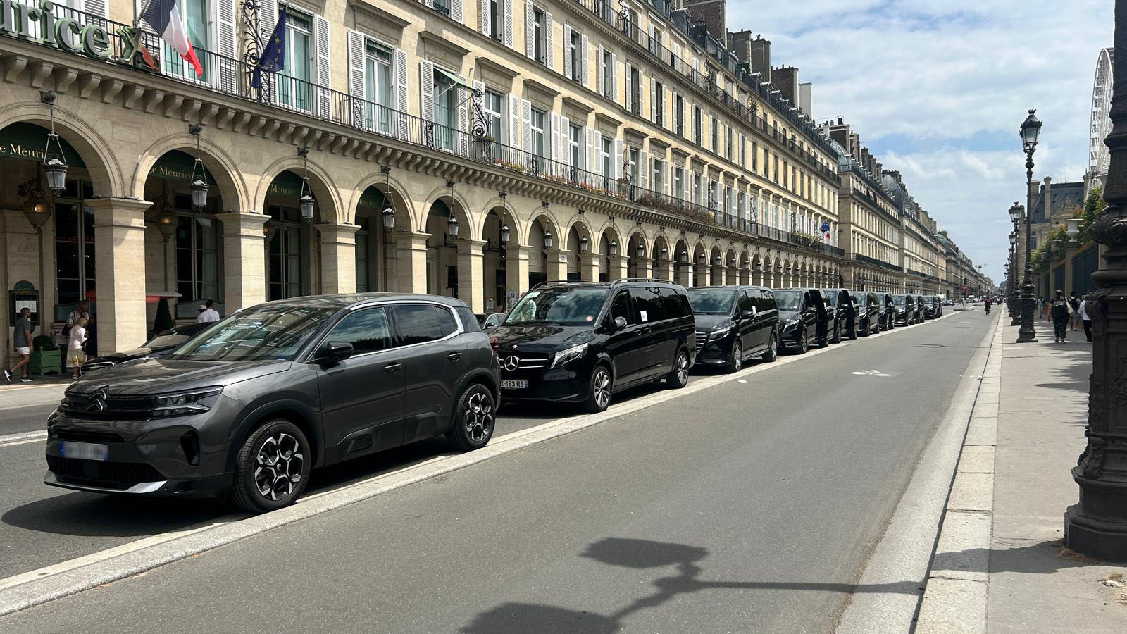 Flotte de berlines Francelimo alignée le long d'une rue à arcades à Paris