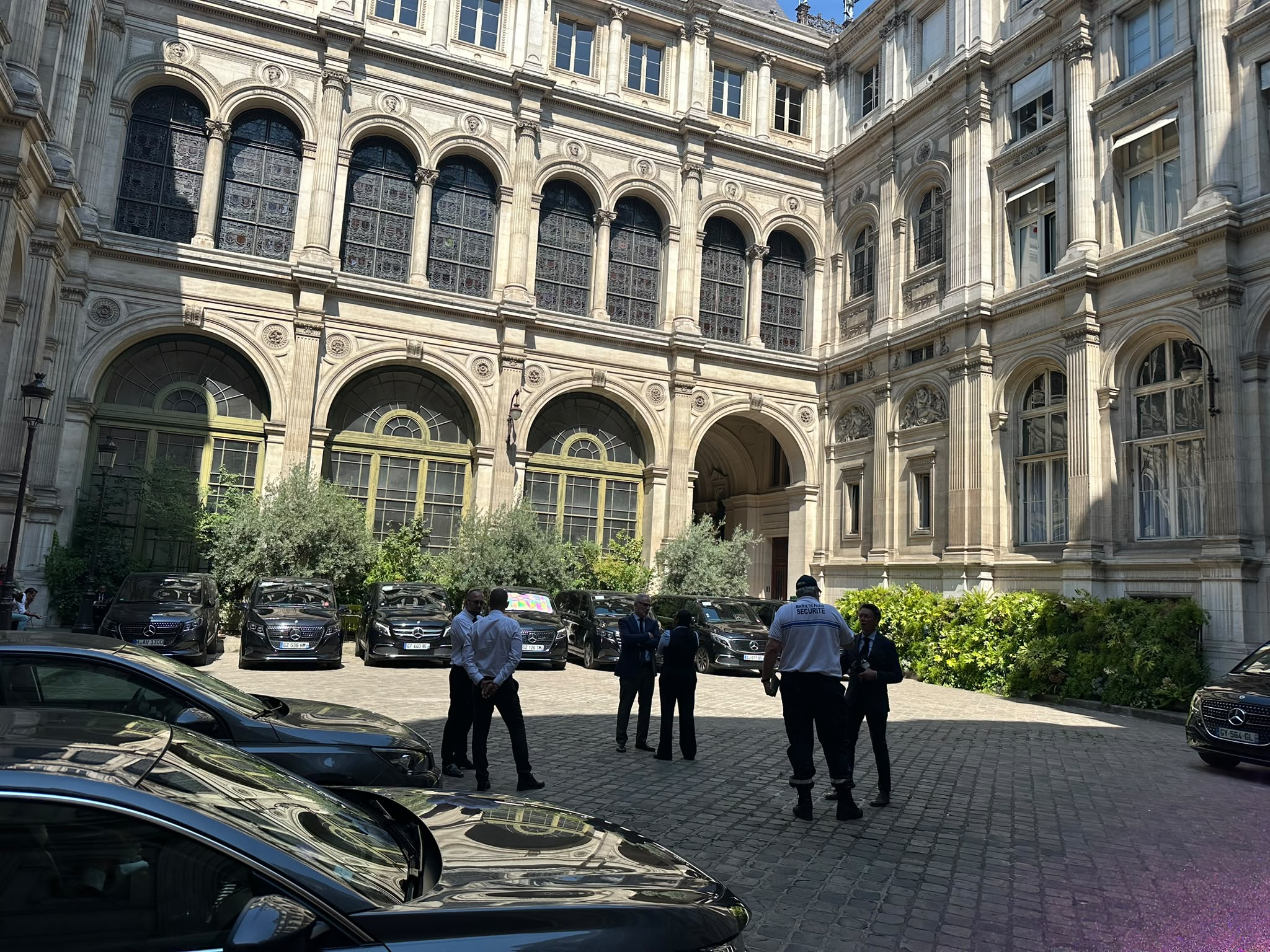 Flotte de véhicules Francelimo alignée dans la cour d'un hôtel particulier parisien, chauffeurs en tenue